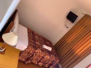 a small bed in a small room with a bed sidx sidx sidx at Hostal El Amigo in Paracas