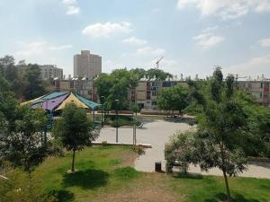 un parque con un estanque y árboles en una ciudad en OPTIMA COMFORT, en Beer Sheva