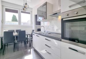 a white kitchen with a table and chairs in it at Bella Apartment in Umag
