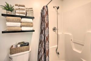 y baño con ducha, aseo y toallas. en Cozy Garden Room in Welsh Mountain Suites!, en New Holland