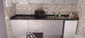 eine kleine Küche mit Spüle und Mikrowelle in der Unterkunft Victoria 1942 in Funchal