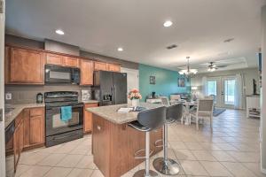 a kitchen with wooden cabinets and a table with chairs at Laguna Vista Home with Resort Perks Near Beach! in Laguna Vista