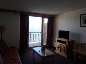 un salon avec une télévision, une table et une fenêtre dans l'établissement Appartement de 2 Pièces avec Balcon et Parking à Proximité des Pistes à Orcières - FR-1-636-192, à Orcières 7 autres photos