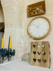 a clock and a wooden block with hearts on it at A charming and cosy townhouse in a quaint village in Sannat