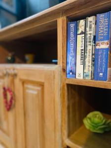 a wooden book shelf with books on it at A charming and cosy townhouse in a quaint village in Sannat