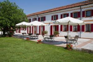 a group of chairs and umbrellas in front of a building at Ca' Tessera Venice Airport in Tessera