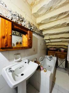 a bathroom with a sink and a mirror at A charming and cosy townhouse in a quaint village in Sannat