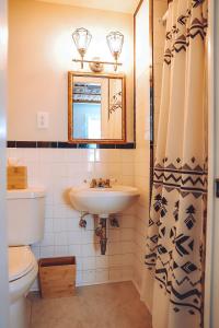 a bathroom with a sink and a toilet and a mirror at La Posada in Milford +33 photos