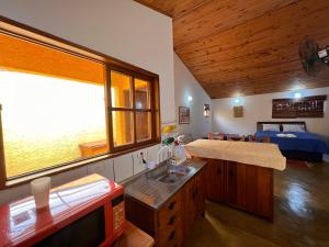 a room with a sink and a bedroom with a bed at Hospedaria Vila Khepri in Gonçalves