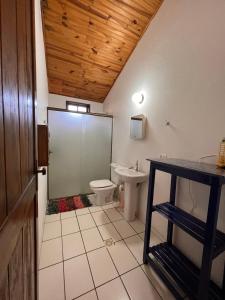 a bathroom with a toilet and a sink at Hospedaria Vila Khepri in Gonçalves