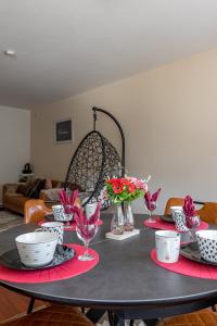 a table with plates and bowls and flowers on it at Luxe apt with parking & garden in wilrijk antwerp in Antwerp