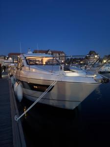 Puissance, Elegance et Style, Yacht à Deauville في دوفيل: قارب أبيض مرسى في ميناء في الليل