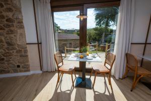 a dining room with a table and chairs and a window at Pensión *** O Relax do Río in Muxia