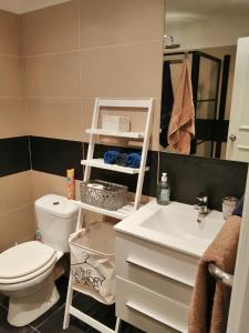 a bathroom with a white toilet and a sink at Tropical Palms apartment Mauritius in Pointe aux Cannoniers
