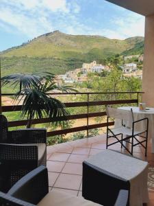 a balcony with a table and chairs and a mountain at Affittacamere La Vigna in Serramezzana