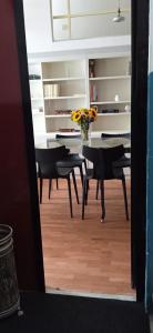 un comedor con mesa y sillas y un jarrón de flores en House City Bari, en Bari