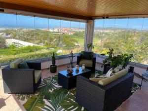 een balkon met banken en een tafel en stoelen bij Villa Casa Dina in Casal da Lagoa Seca