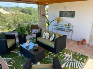 uma sala de estar com um sofá e cadeiras num tapete em Villa Casa Dina em Praia del Rei
