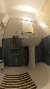 La salle de bains est pourvue d'un lavabo, d'un miroir et d'un tapis. dans l'établissement MAYA, à Paphos