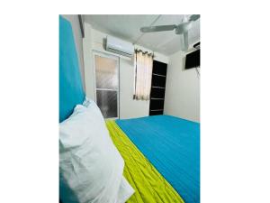 - une chambre dotée d'un lit avec une couverture bleue et jaune dans l'établissement Hotel Ocean Huatulco, à Santa Cruz Huatulco