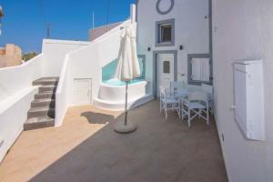a patio with an umbrella and a table with chairs at Kafenes Home in Mesaria