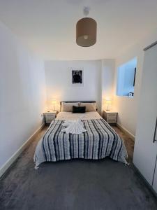 een slaapkamer met een groot bed met 2 nachtkastjes bij Cotton Apartment Chinatown Central Stay in Birmingham