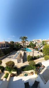 a view of a resort with a pool and palm trees at MAYA in Paphos City