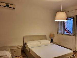 1 dormitorio con cama, lámpara y ventana en 3 bedrooms villa with private pool and wifi at Caccamo 9 km away from the beach, en Caccamo