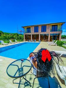 a house with a pool and a table with a red bow at Chateau ikalto in Ikalto