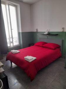 - un lit rouge avec 2 serviettes dans l'établissement Hotel Geoffroy Marie Opéra, à Paris