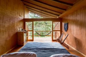 1 dormitorio con cama grande y ventana grande en Pueblo del Sol Hotel Retreat, en Puerto Escondido