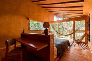 1 dormitorio con escritorio, 1 cama y ventana en Pueblo del Sol Hotel Retreat, en Puerto Escondido