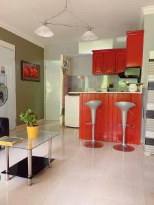 cocina con armarios rojos y mesa de cristal en Moderno Y Elegante en Santo Domingo