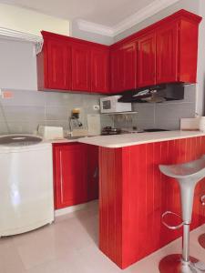 a red kitchen with red cabinets and a sink at Moderno Y Elegante in Santo Domingo