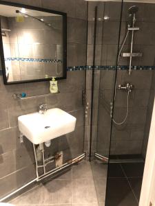 a bathroom with a sink and a shower with a mirror at Hotel Geoffroy Marie Opéra in Paris