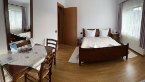 a bedroom with a bed and a table and a dining room at Pensiunea Funivia in Săcele