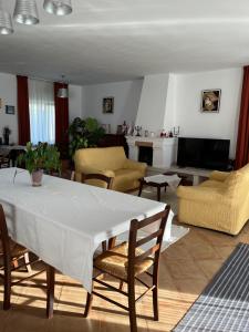 sala de estar con mesa blanca y sillas en Pensiunea Funivia, en Săcele