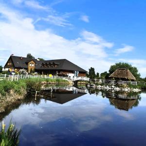 un reflejo de un edificio en un río en Karczma Góralska, en Wisznice