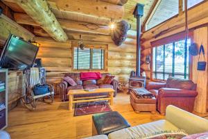 a living room with leather furniture in a log cabin at Rustic Hideaway Fire Pits, Grills, 87 Acres! 