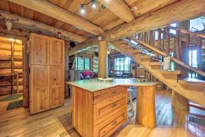 a kitchen with wooden cabinets and a staircase in a log cabin at Rustic Hideaway Fire Pits, Grills, 87 Acres! 
