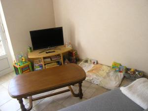 sala de estar con mesa y TV en una habitación en Charmant gîte Haut-Marnais, en Montcharvot