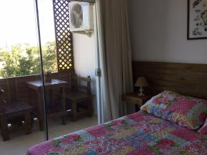 a bedroom with a bed and a table and a window at Residencial Dois Amores Apartamentos in Florianópolis