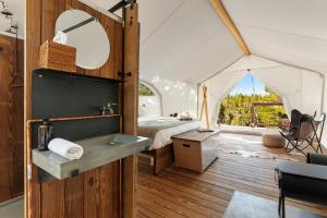 een slaapkamer in een tent met een bed en een bureau bij Under Canvas Bryce Canyon in Widtsoe