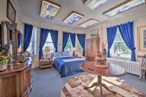 1 dormitorio con cortinas azules, 1 cama y 1 mesa en Luxurious Annville Home about 8 Mi to Hersheypark en Annville