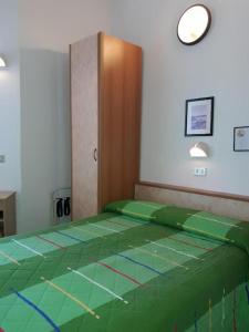 Una cama en una habitación con una cubierta verde. en Hotel Imperiale, en Cesenatico