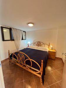 1 dormitorio con cama de madera y manta azul en Appartamento a pochi minuti da Acciaroli sul mare, en Agnone