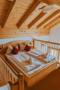a large wooden bed in a room with wooden ceilings at Reitlehenalm in Altenmarkt im Pongau