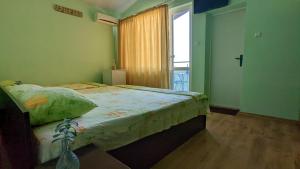 a bedroom with a large bed and a window at Stoyanovi Guest House in Chernomorets