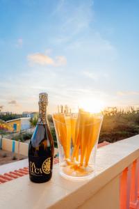 a bottle of beer and two glasses on a ledge at Villa Encantada Aruba in Noord