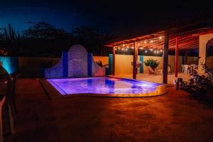 a house with a swimming pool at night at Villa Encantada Aruba in Noord